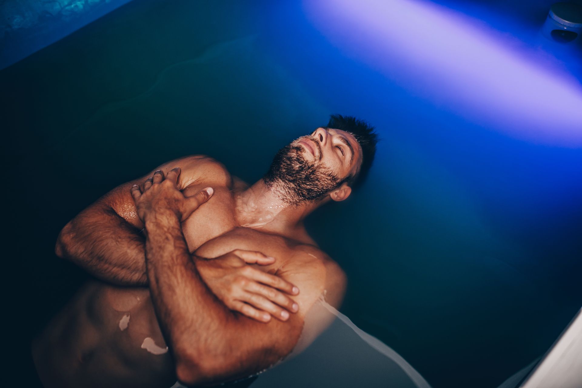 Eine Frau schwimmt mit geschlossenen Augen in einer Badewanne.