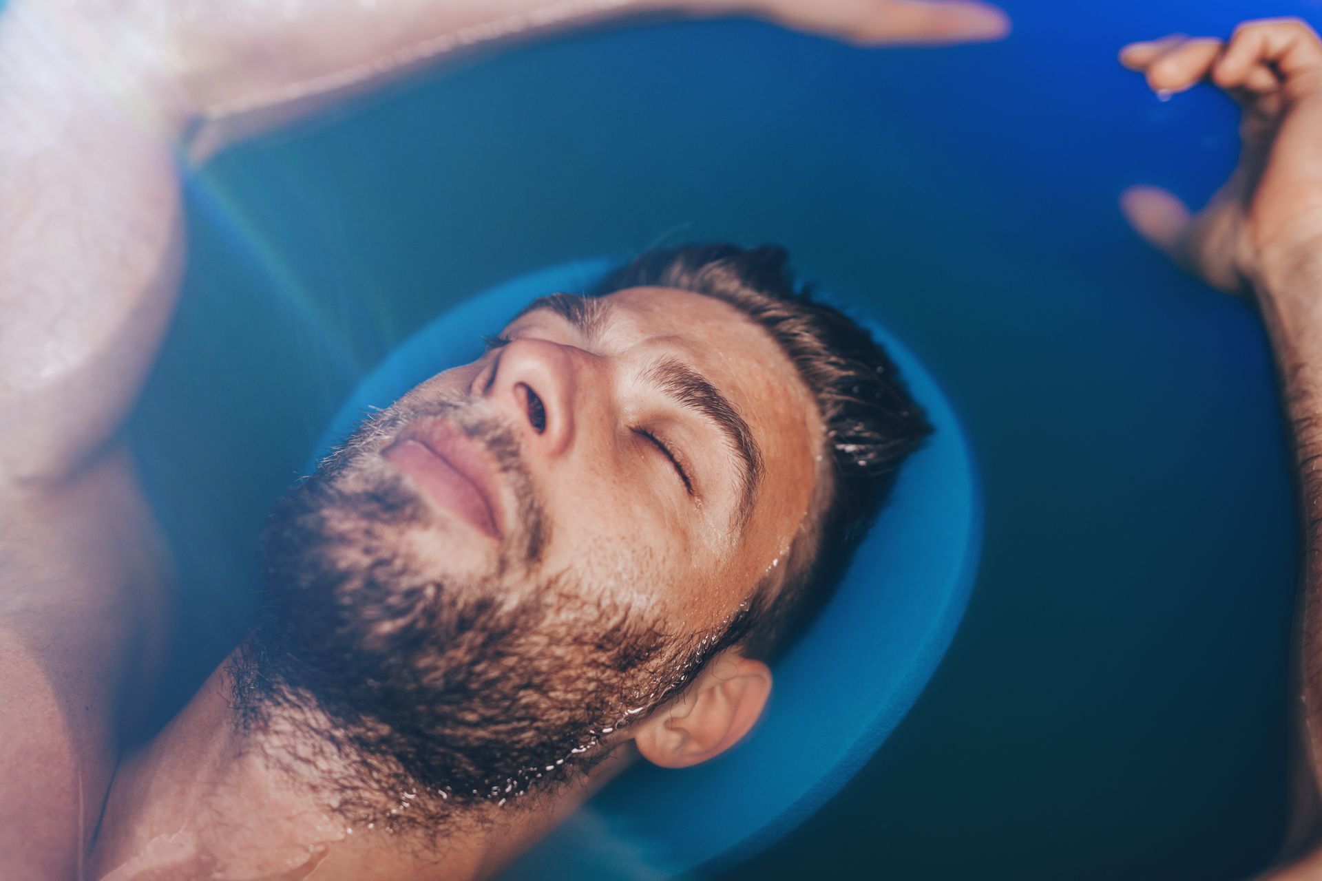 Eine Frau schwimmt mit geschlossenen Augen in einer Badewanne.