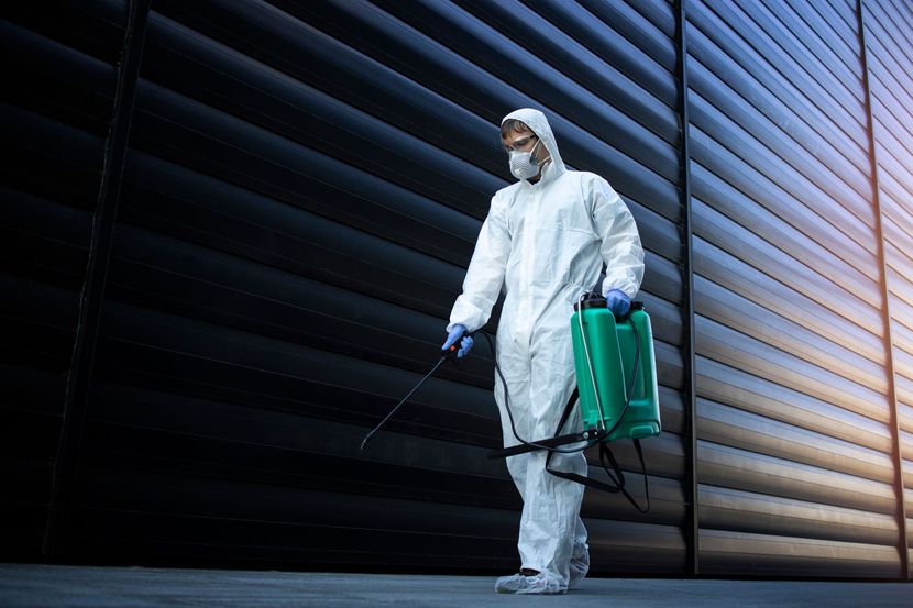 Trabajador con chaleco de seguridad inspeccionando extintores en una instalación industrial.
