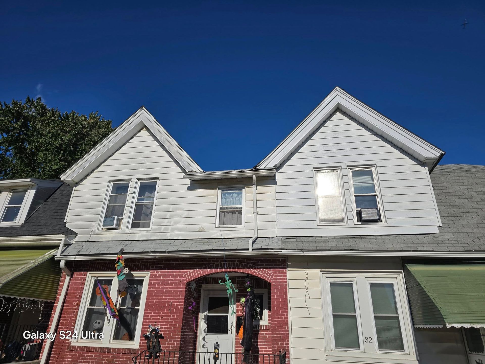 Row houses with white siding and a blue sky above.