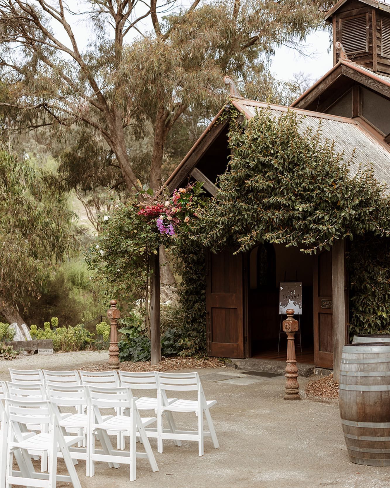A row of white chairs are lined up in front of a building