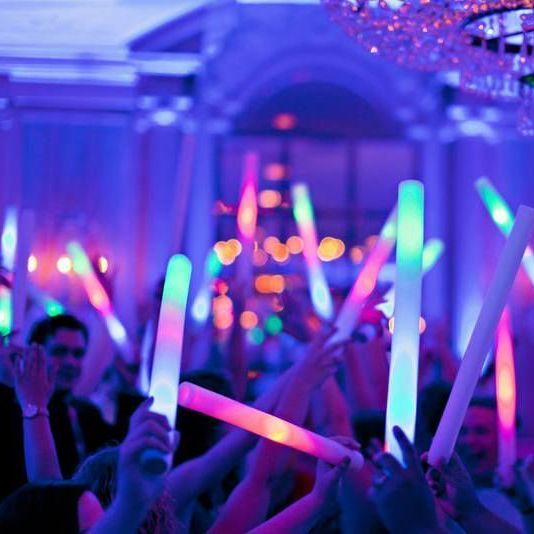 A crowd of people holding glow sticks in their hands