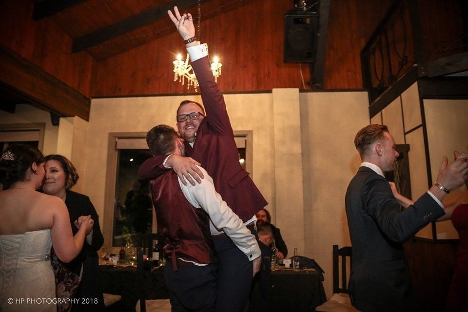 A group of people are dancing at a wedding reception.