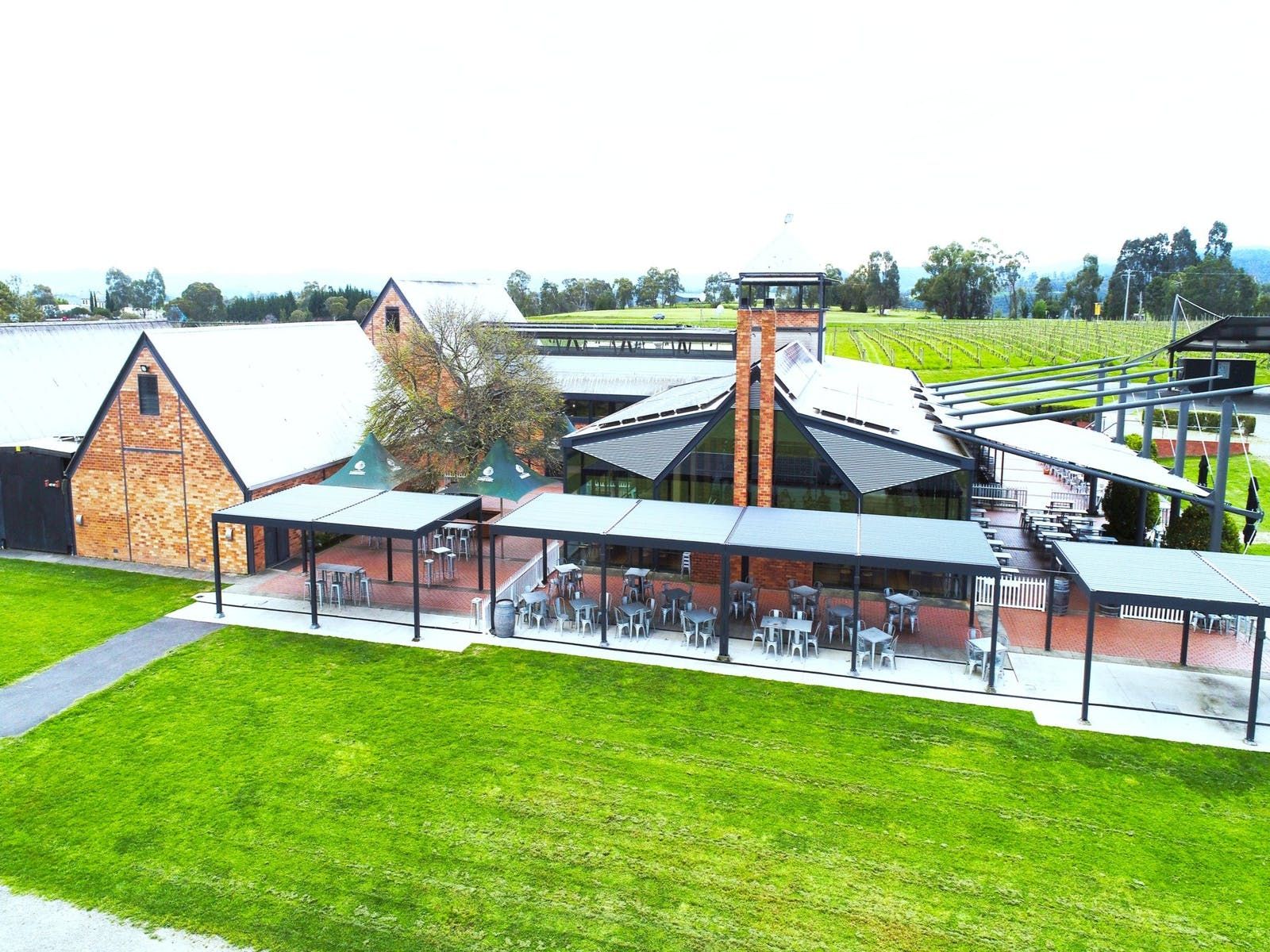 An aerial view of a large building with tables and chairs in front of it.