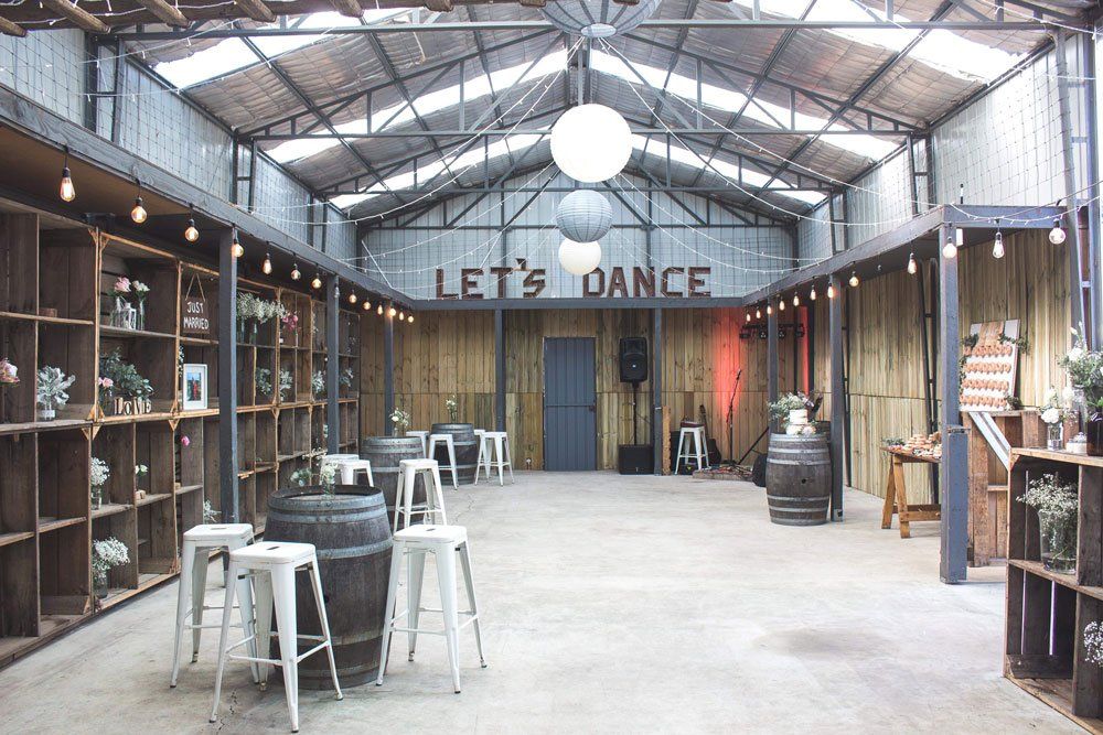 A large room with tables and barrels and a sign that says let 's dance.