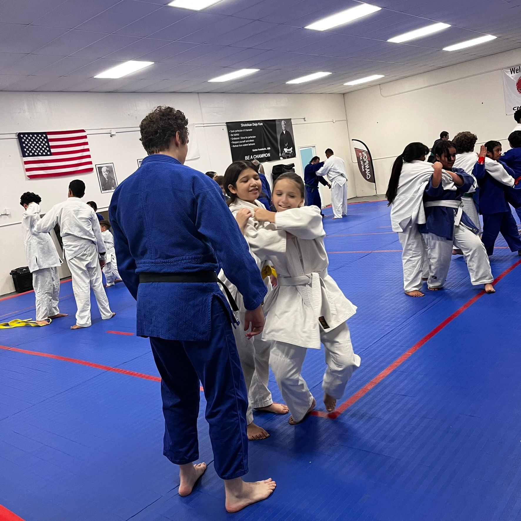 Kids and adults practice Judo throws at Champion Martial Arts & Fitness in Pasadena, Texas, building confidence.