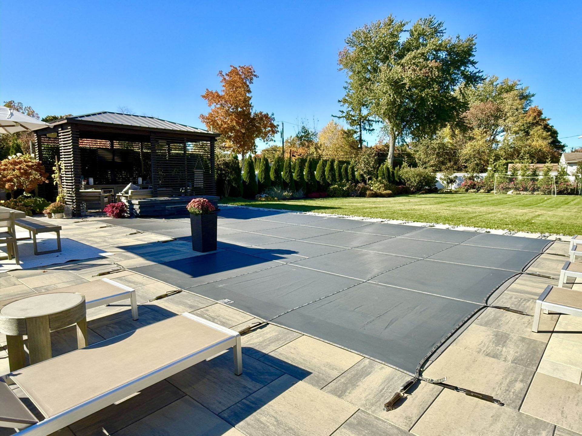 Winterized J-shaped built-in, inground pool with safety Loop - Loc mesh cover to protect it. Allows melting snow and rain to drain through it. Brass anchors are flush to the paver height. Winterized J-shaped built-in, inground pool with safety Loop - Loc mesh cover to protect it. Allows melting snow and rain to drain through it. Brass anchors are flush to the paver height.