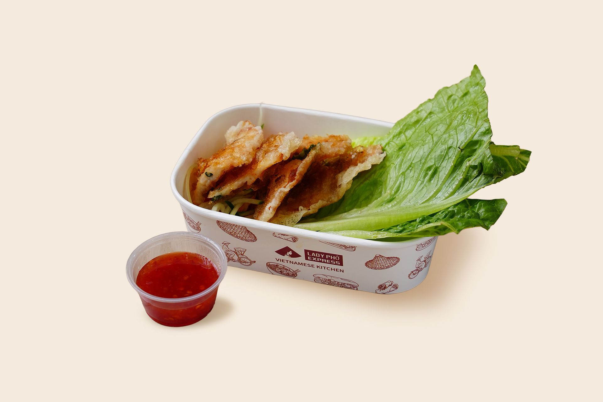 Takeout tray with fried dumplings, lettuce, and a small cup of red dipping sauce