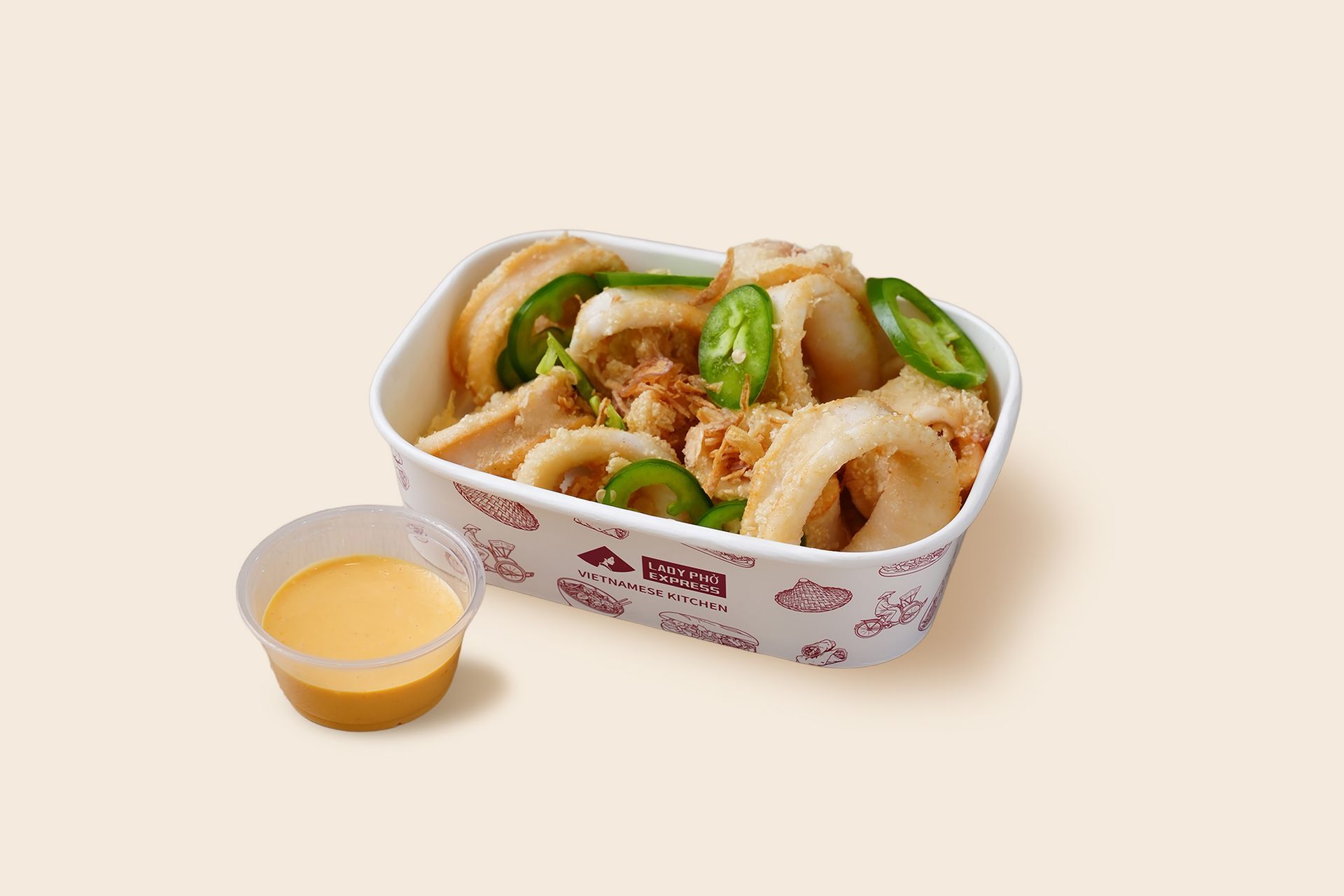 Takeout box of fried chicken strips with green garnishes and a dipping sauce cup on a beige background