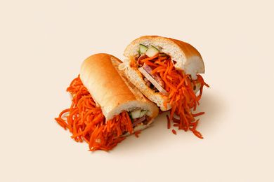 Two halves of a sandwich with shredded orange filling on a light background