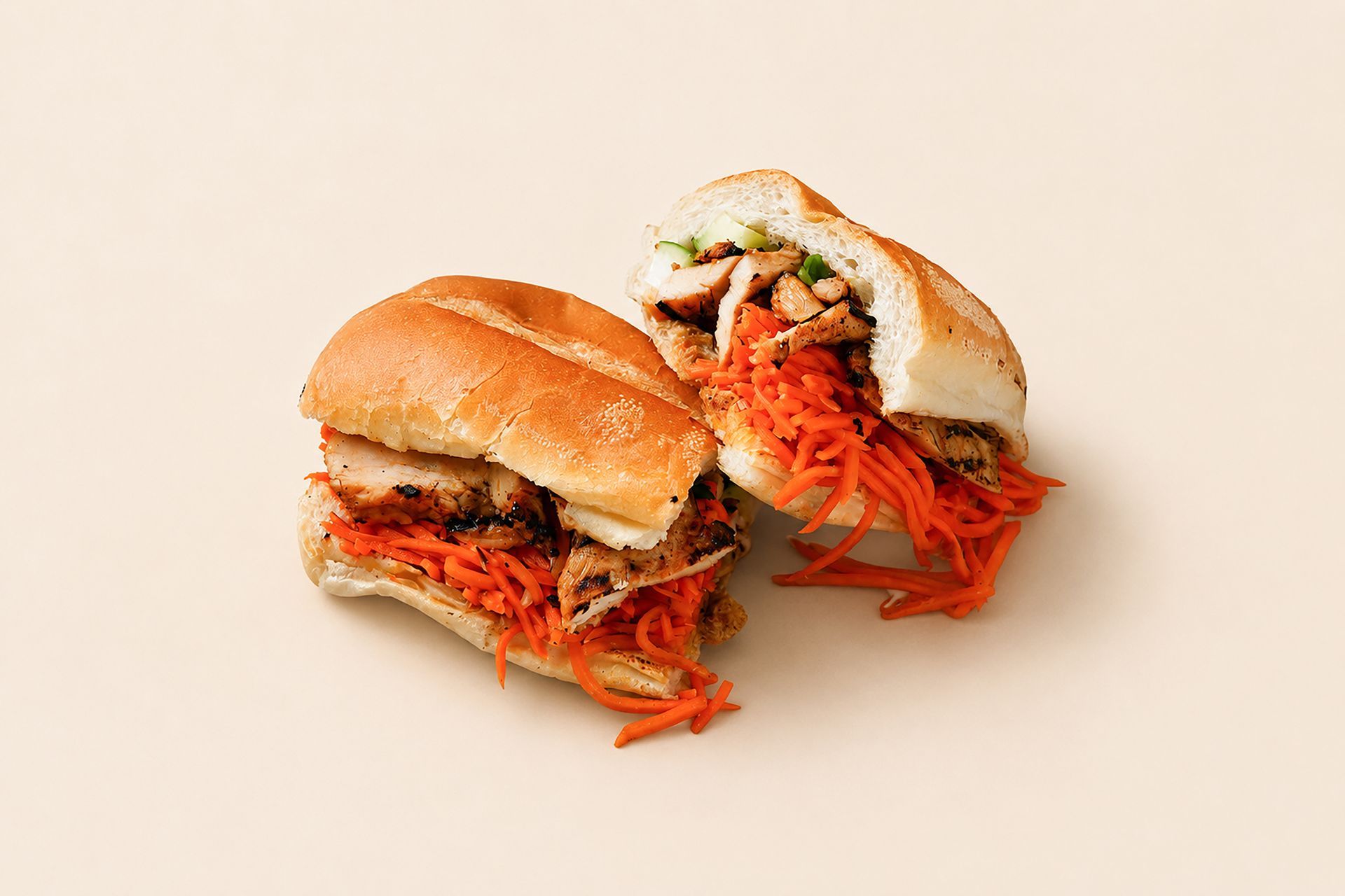 Two sandwich halves filled with shredded meat on a light beige background