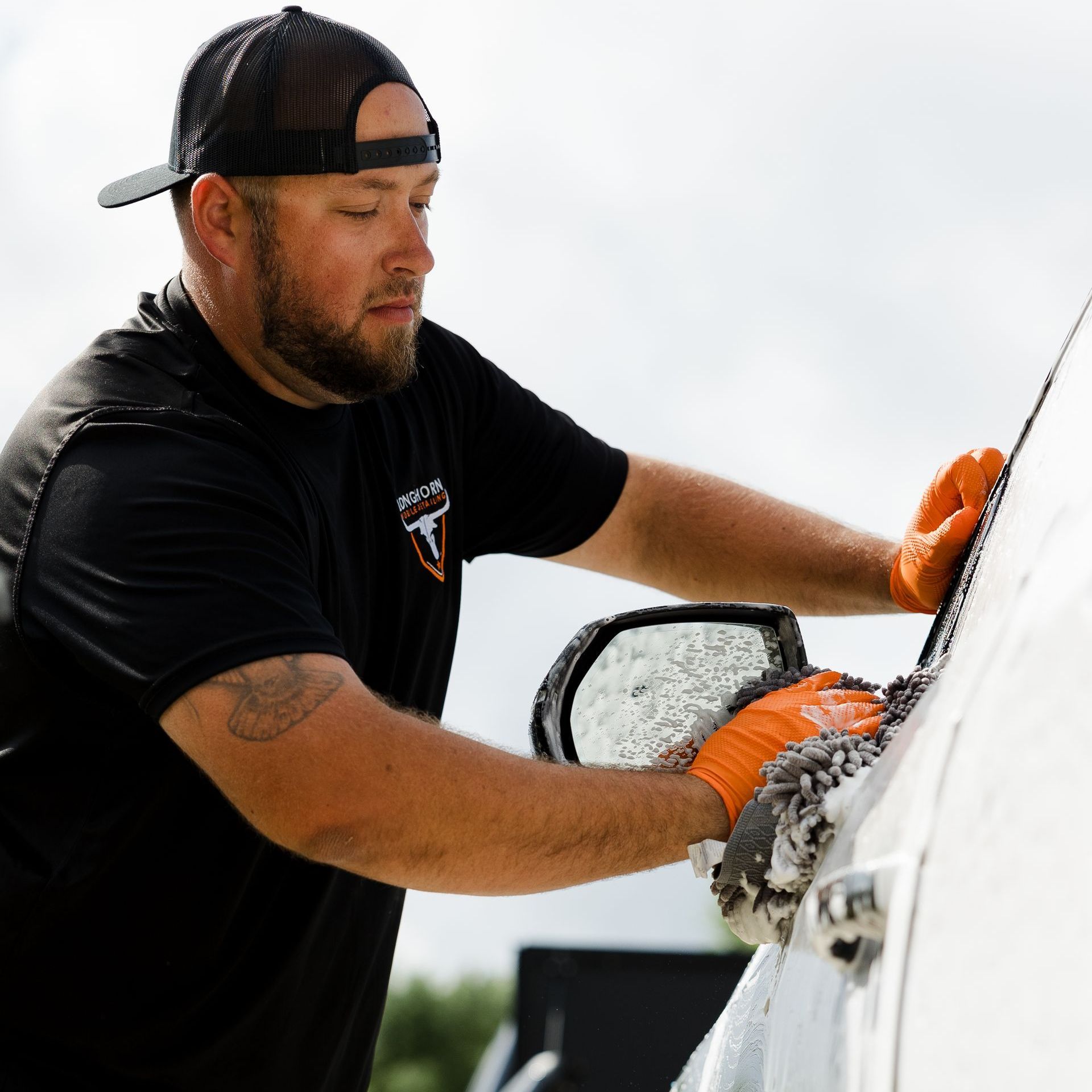 Monthly concierge mobile car detailing in Austin, TX. Man washing side of car during monthly concierge mobile car detailing in Austin, TX.