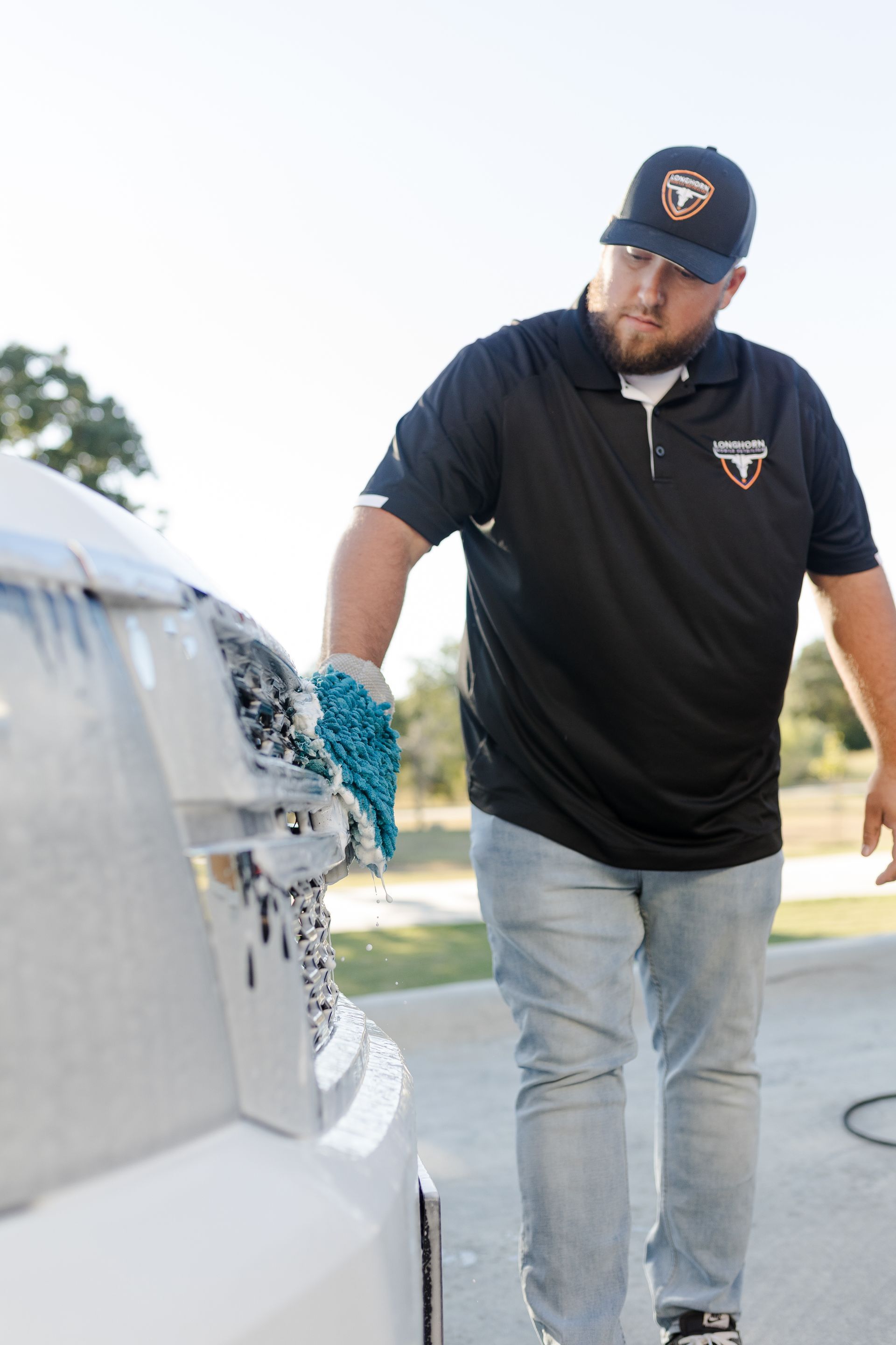 Owner of Longhorn Mobile Detailing cleaning front of truck Best Mobile Detailer in Dripping Springs and Austin