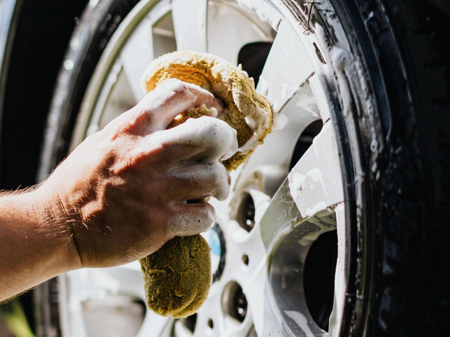 Silver Package | Mobile Car Detailing | Lakeway, Bee Cave TX Man cleaning car wheel | Best mobile car and truck detailing with ceramic coatings in West Lake Hills TX
