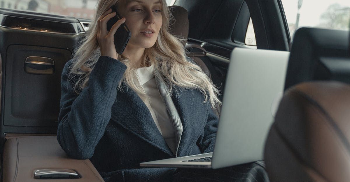 Protect your fleet with mobile detailing in Austin TX Woman on the phone and computer in car - protect your fleet investment with mobile detailing in Buda TX