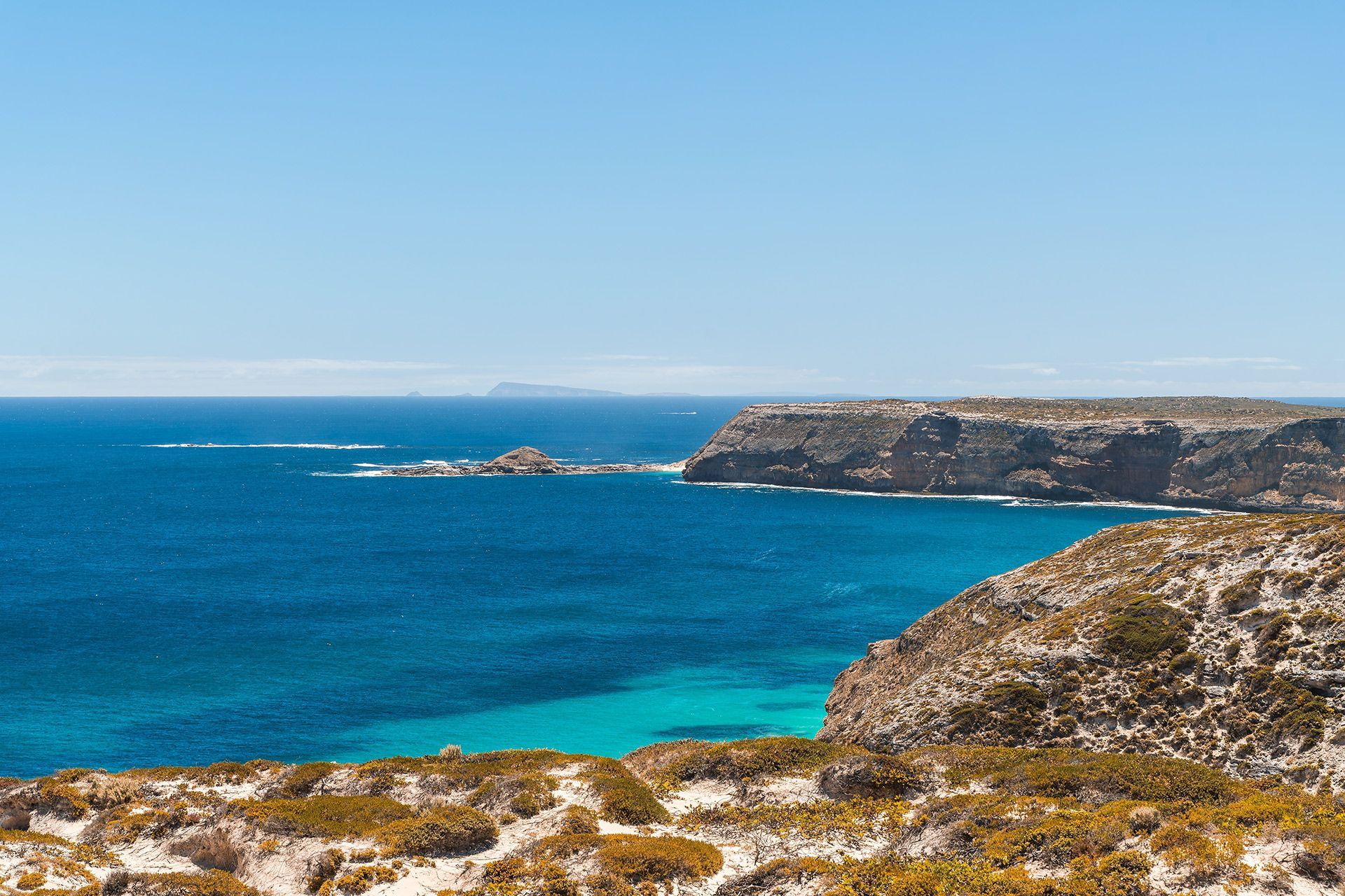 Rocky Coastline with Turquoise Ocean Under a Clear Blue Sky — Premium Electrical Solutions In Innes Park, QLD