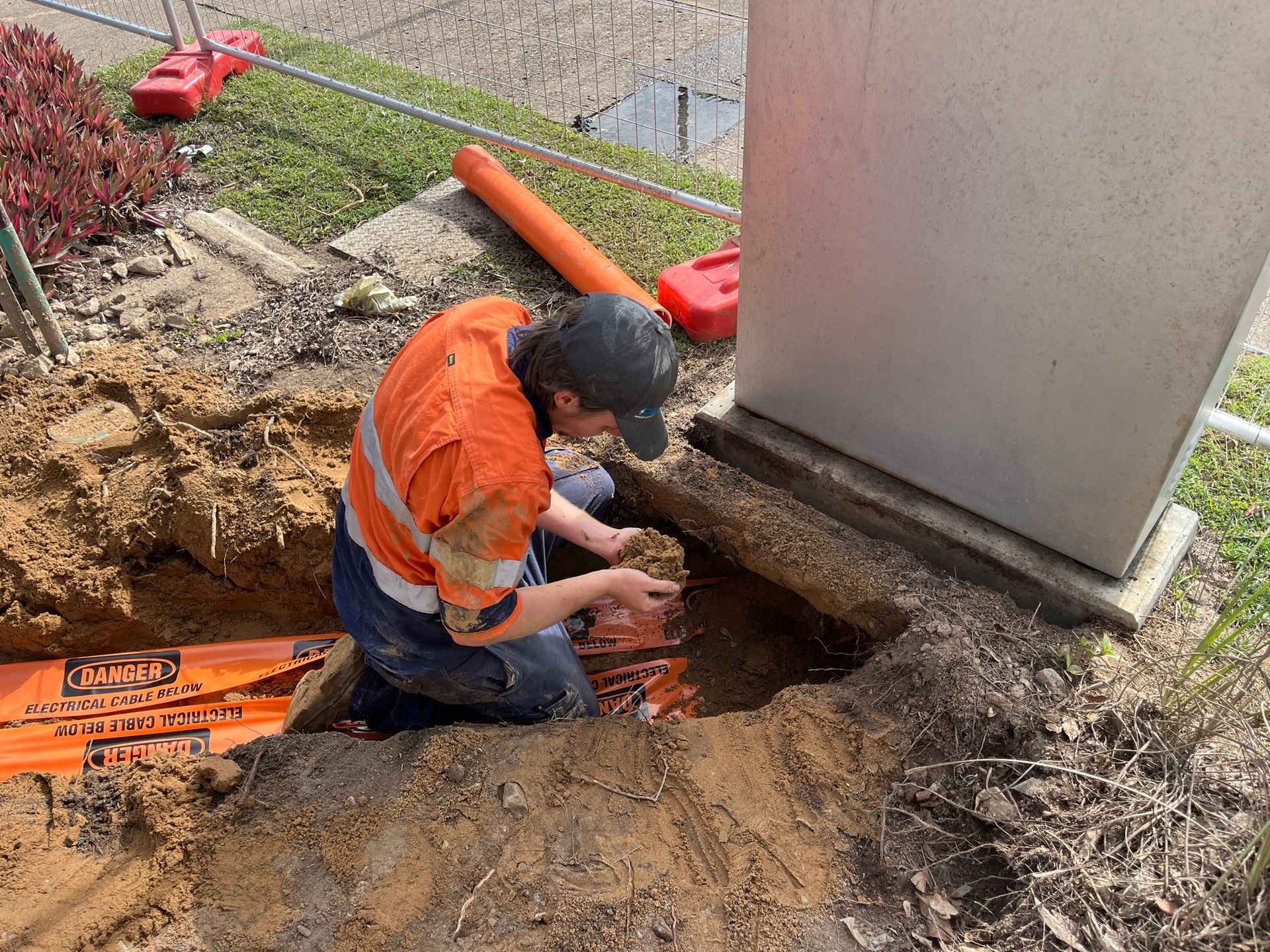 Worker in Orange Safety Jacket Setting up For Electric System — Premium Electrical Solutions In Coral Cove, QLD