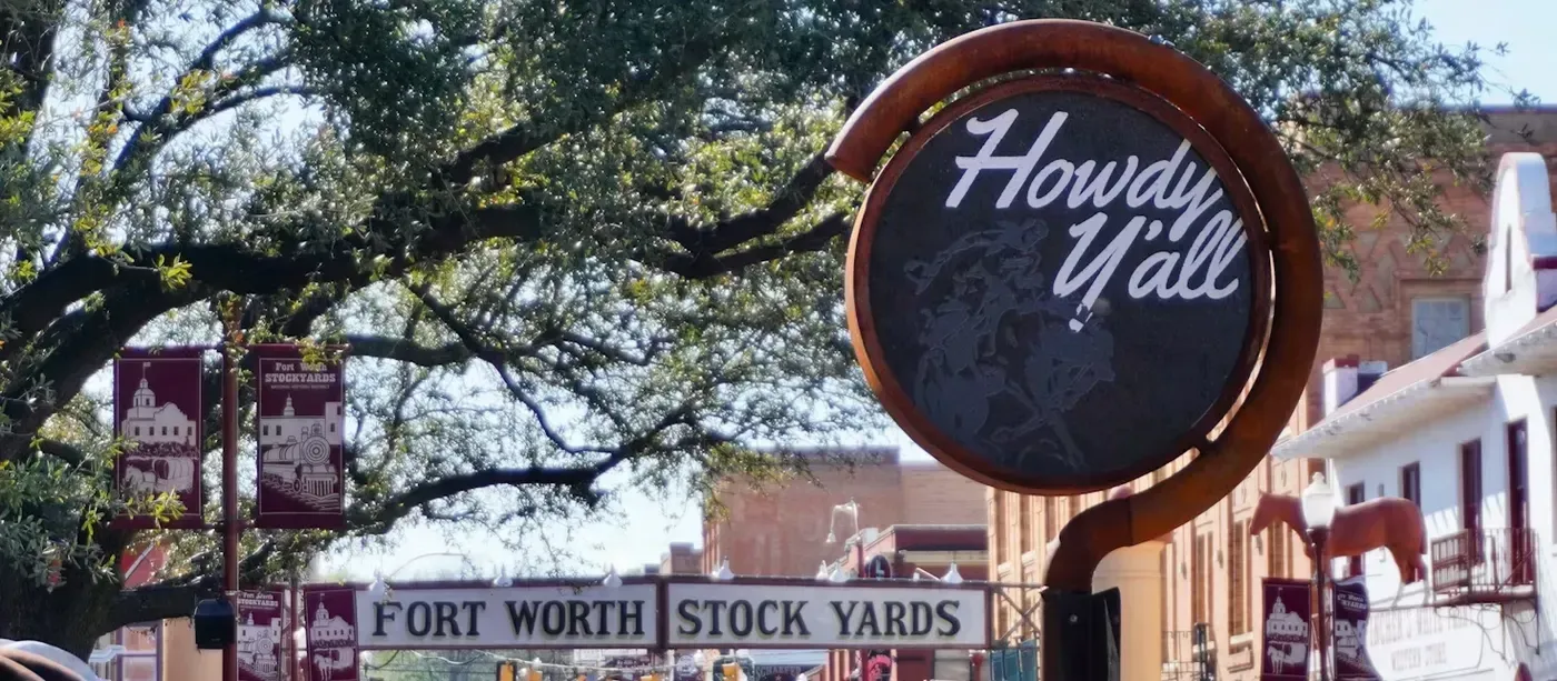 The Fort Worth Stockyards entrance sign, reading “Howdy Y’all,” above the Fort Worth Stock Yards banner.