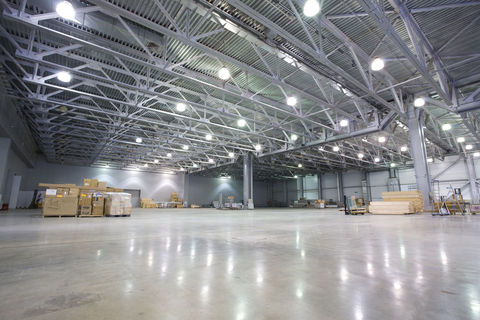 A large empty warehouse with lots of lights on the ceiling.