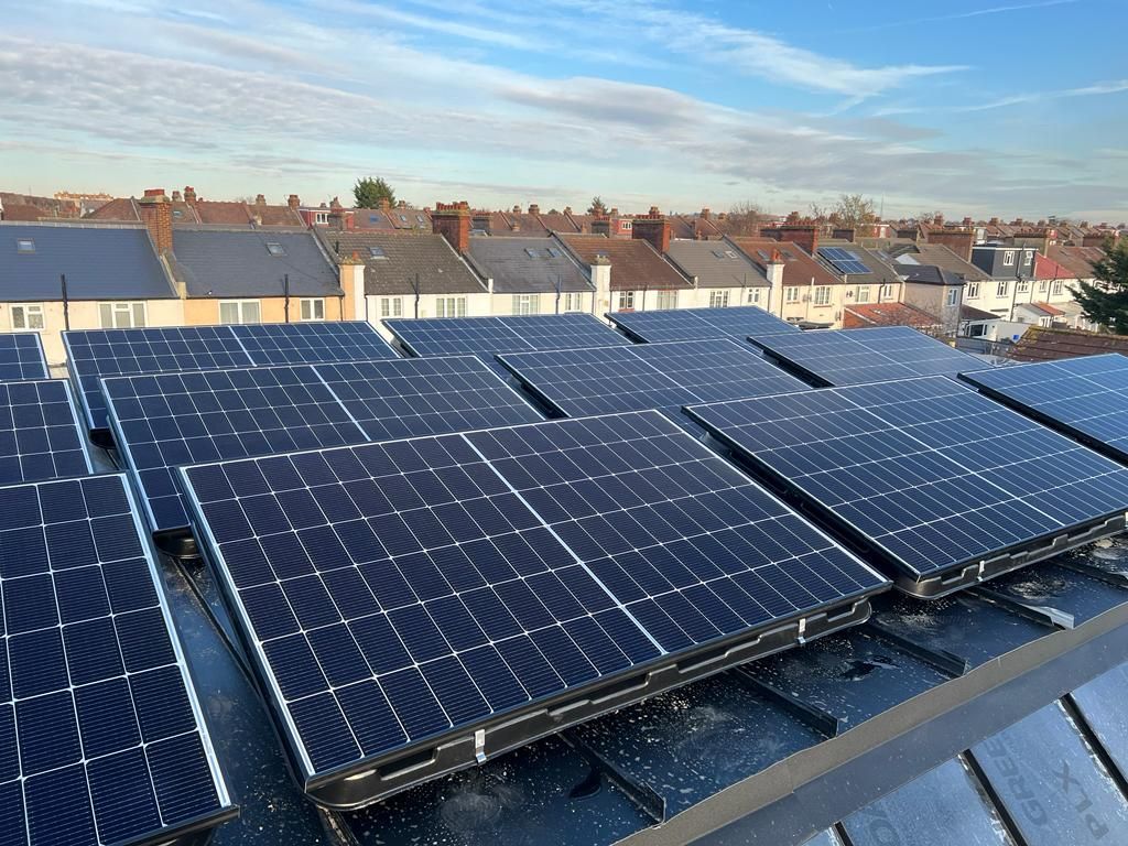 A row of solar panels are sitting on top of a roof.