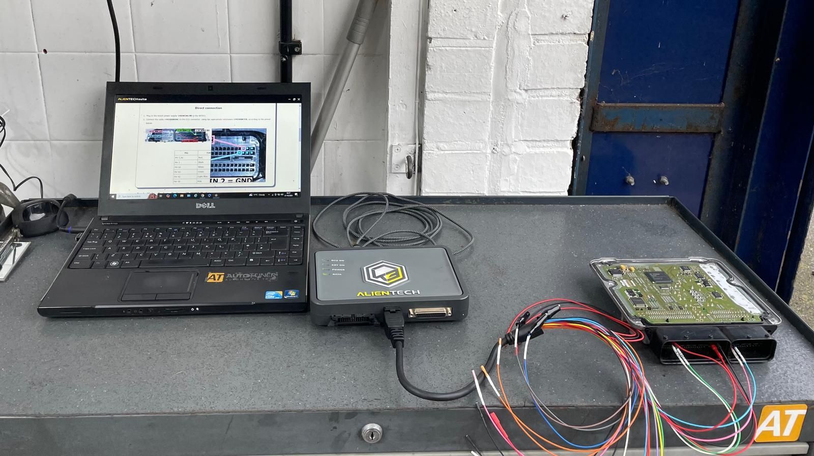A man is working on a car in front of a aa garage