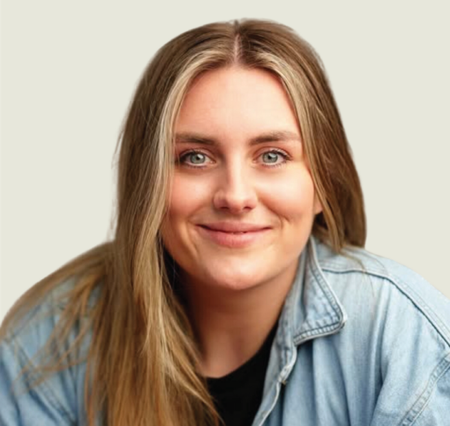 A woman wearing a denim shirt and a black shirt is smiling for the camera.