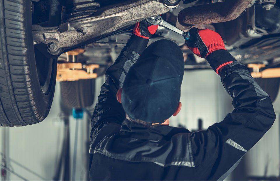 car mechanic repairing under chasis