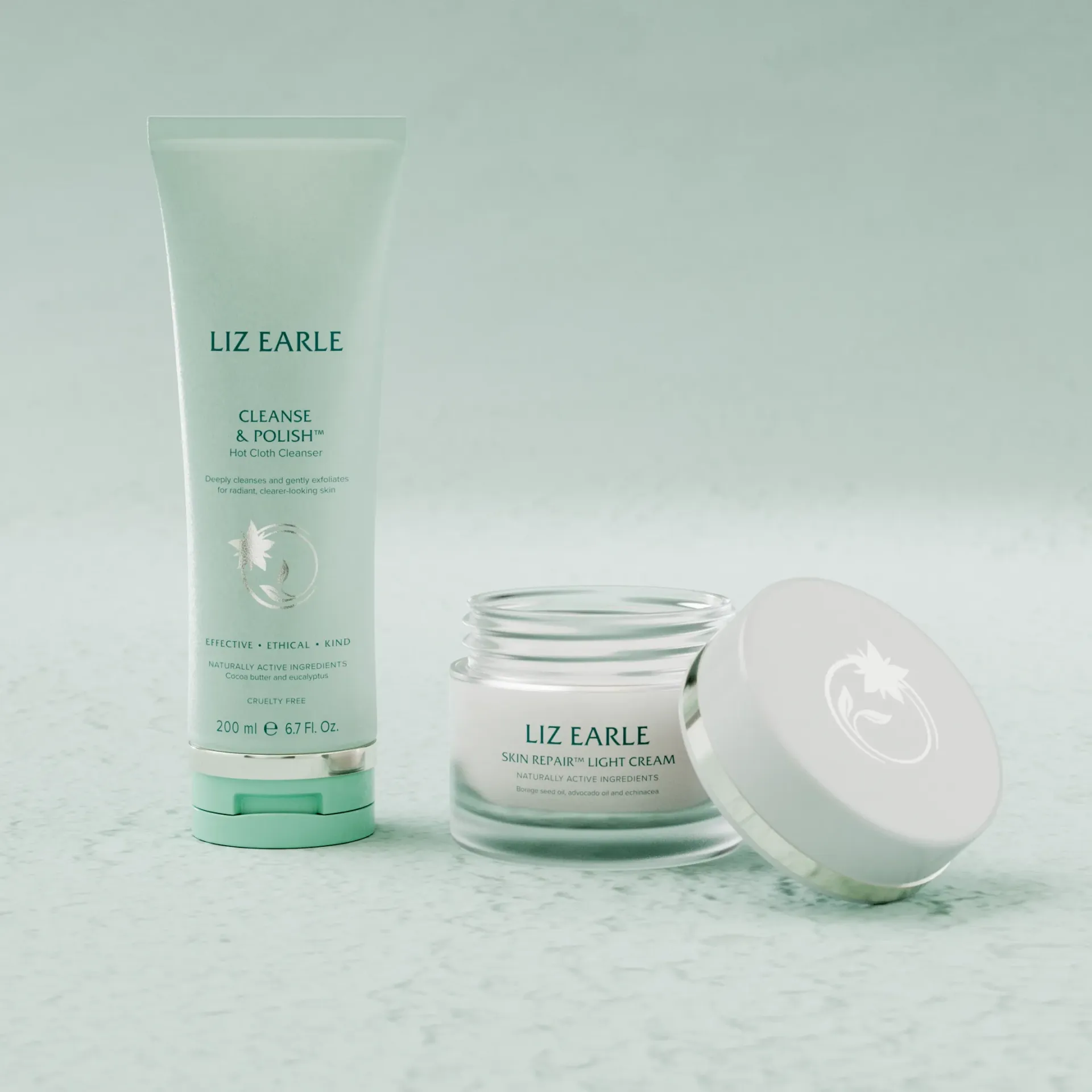 Mint-green skincare tube, cream jar, and lid on a light surface.
