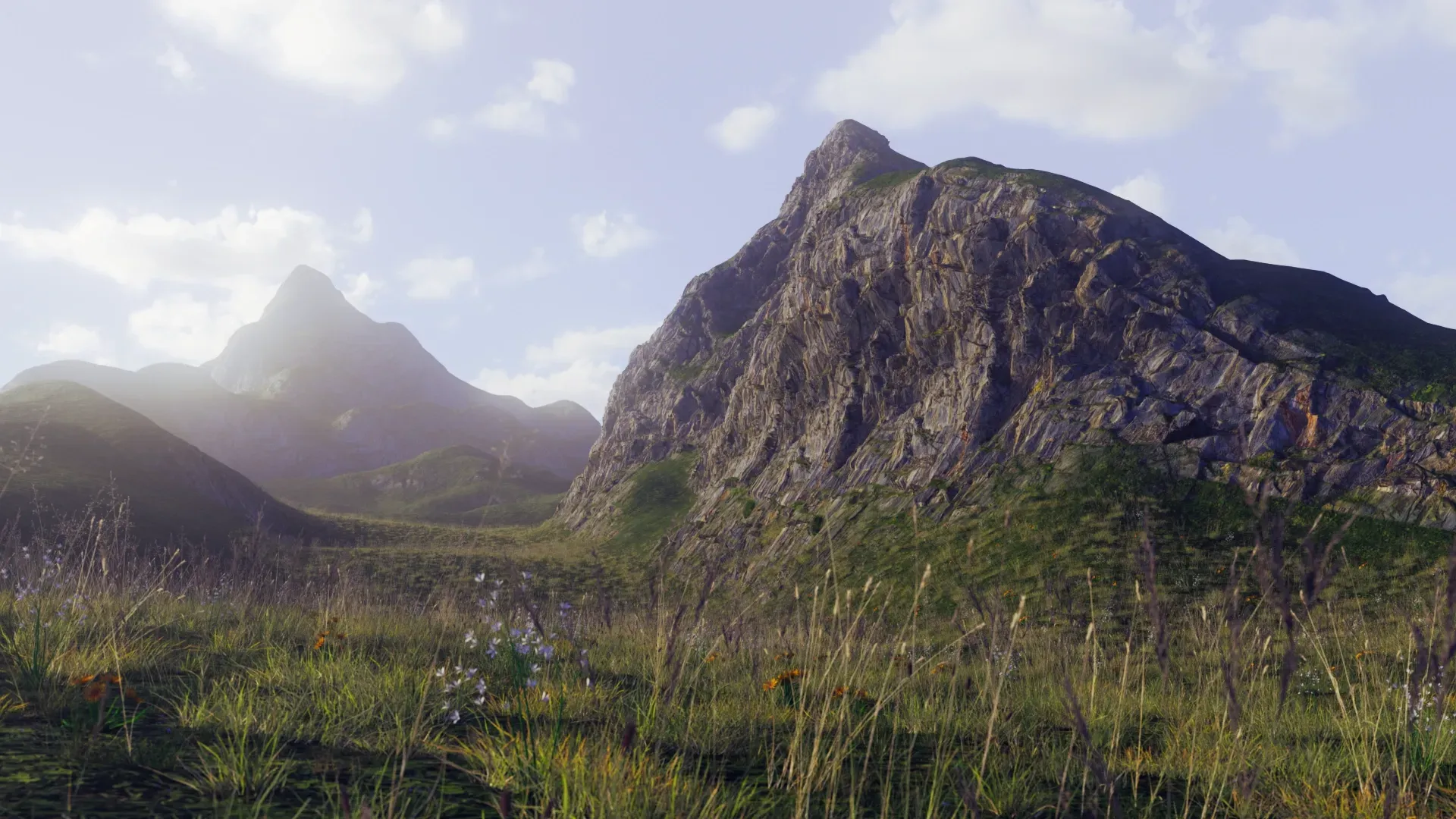 Sunlit rocky mountains rising above a grassy valley under a cloudy sky
