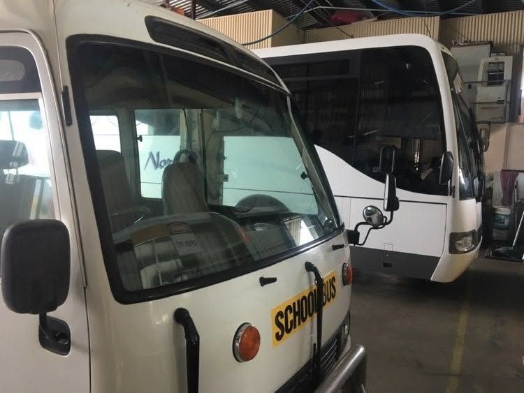 Two White School Buses Parked Indoors — Mobile Windscreens FNQ in Innisfail, QLD