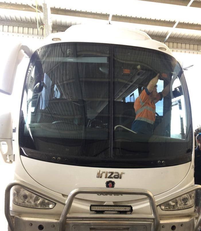 White Bus with A Worker Inside the Windshield — Mobile Windscreens FNQ in Tully, QLD