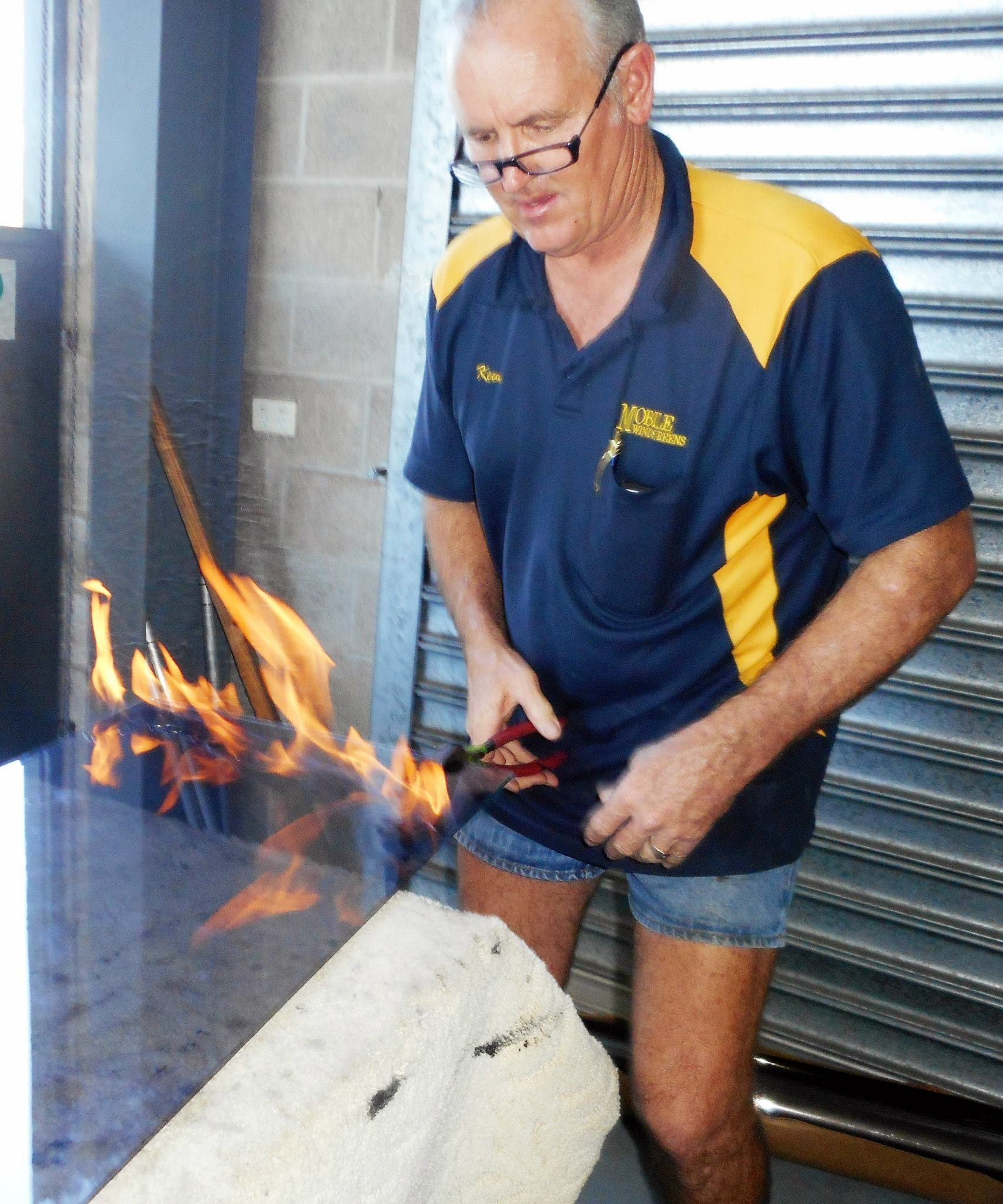 Man Using a Torch to Work on a Concrete Object Flames Visible — Mobile Windscreens FNQ in Atherton, QLD