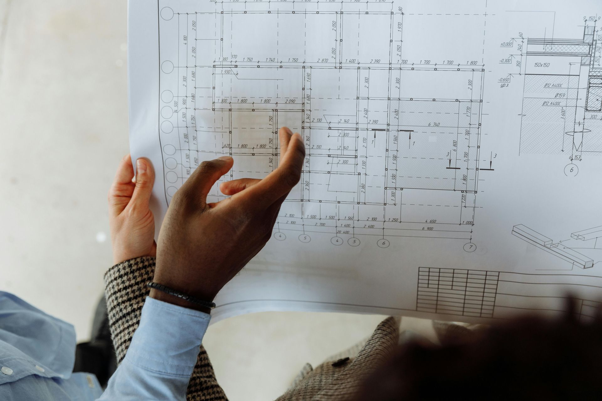 Hands reviewing a report with blue charts and graphs on a desk