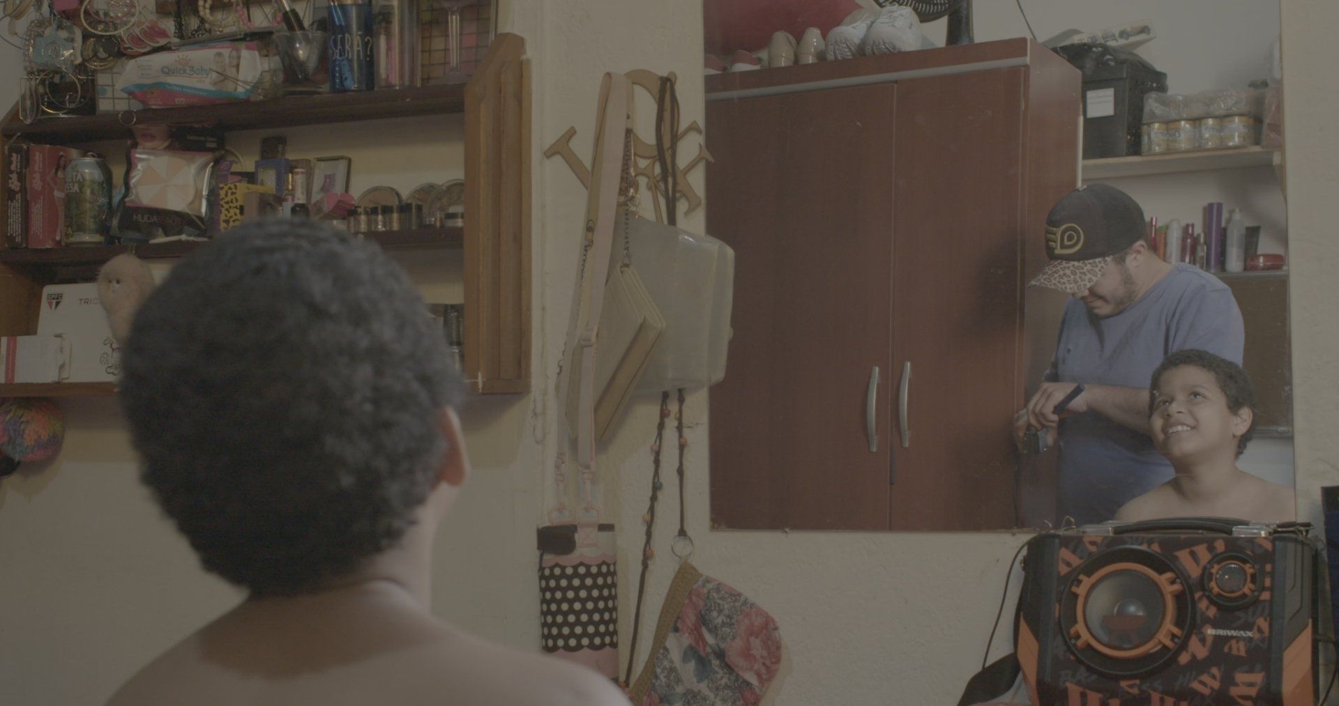 Um homem sem camisa está diante de um espelho em uma sala.
