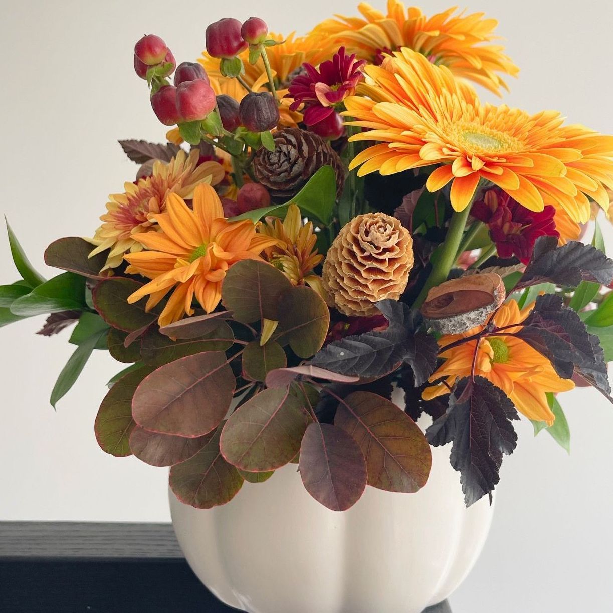 Full flower arrangement with a red/magenta colour palette on a festive table