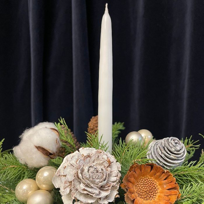 Full flower arrangement with a red/magenta colour palette on a festive table