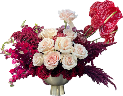 Red and pink floral arrangement, featuring roses and tropical flowers 