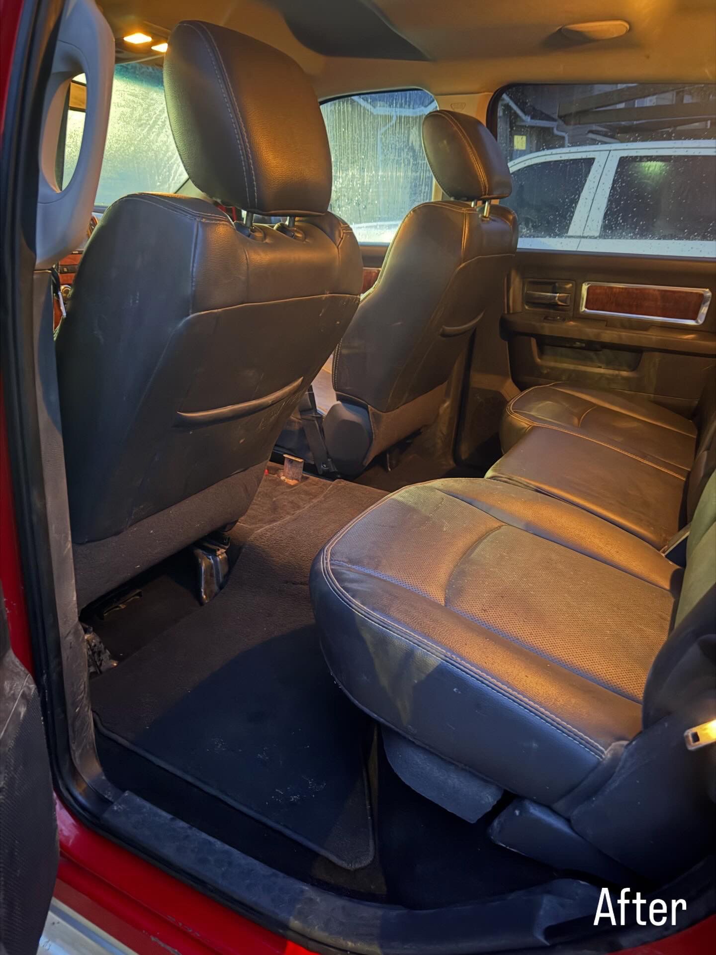 Car interior after cleaning, showing front and rear seats, dark upholstery, and floor mats.