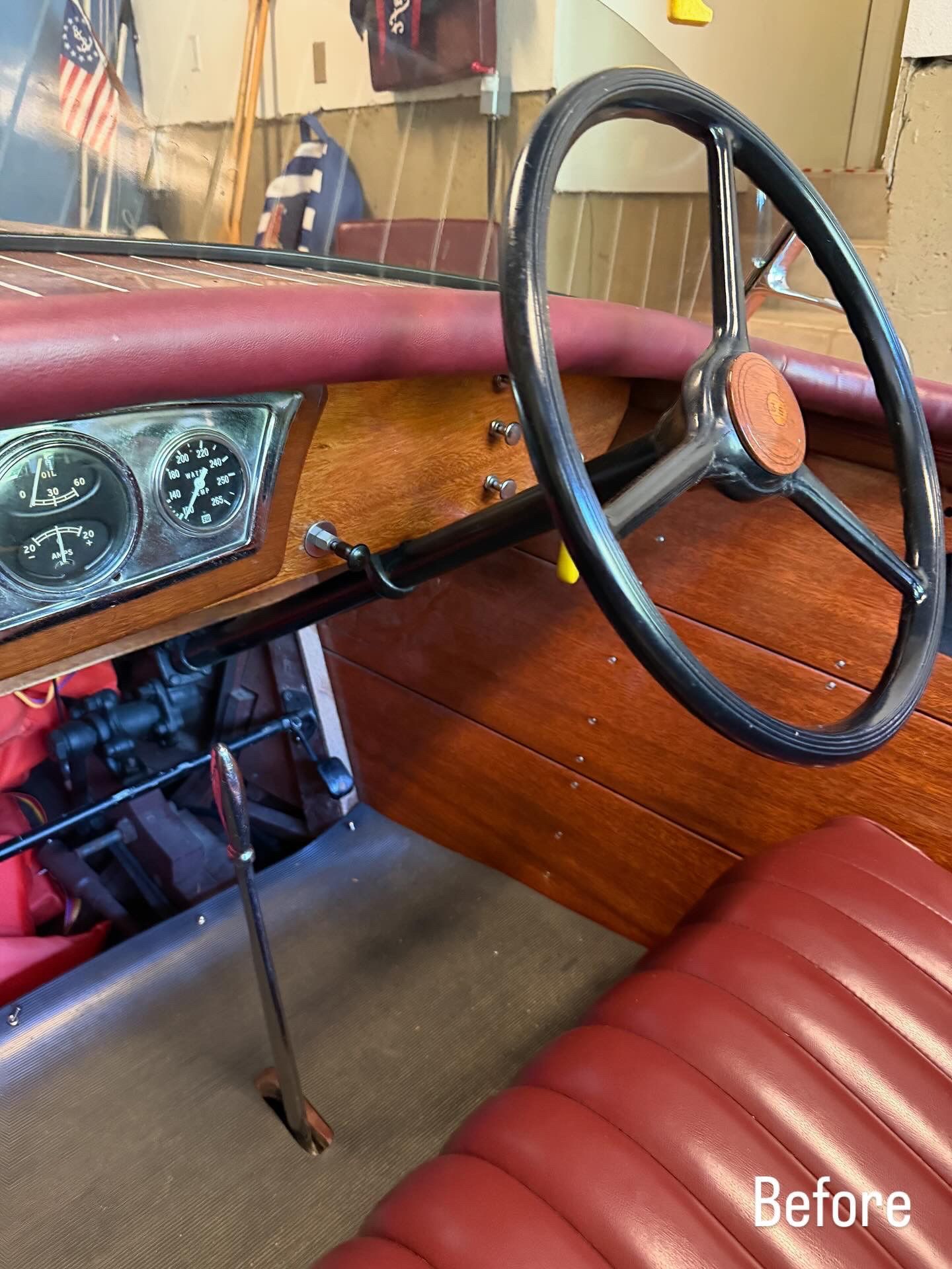 Vintage boat cockpit with red seats, wood paneling, and a steering wheel