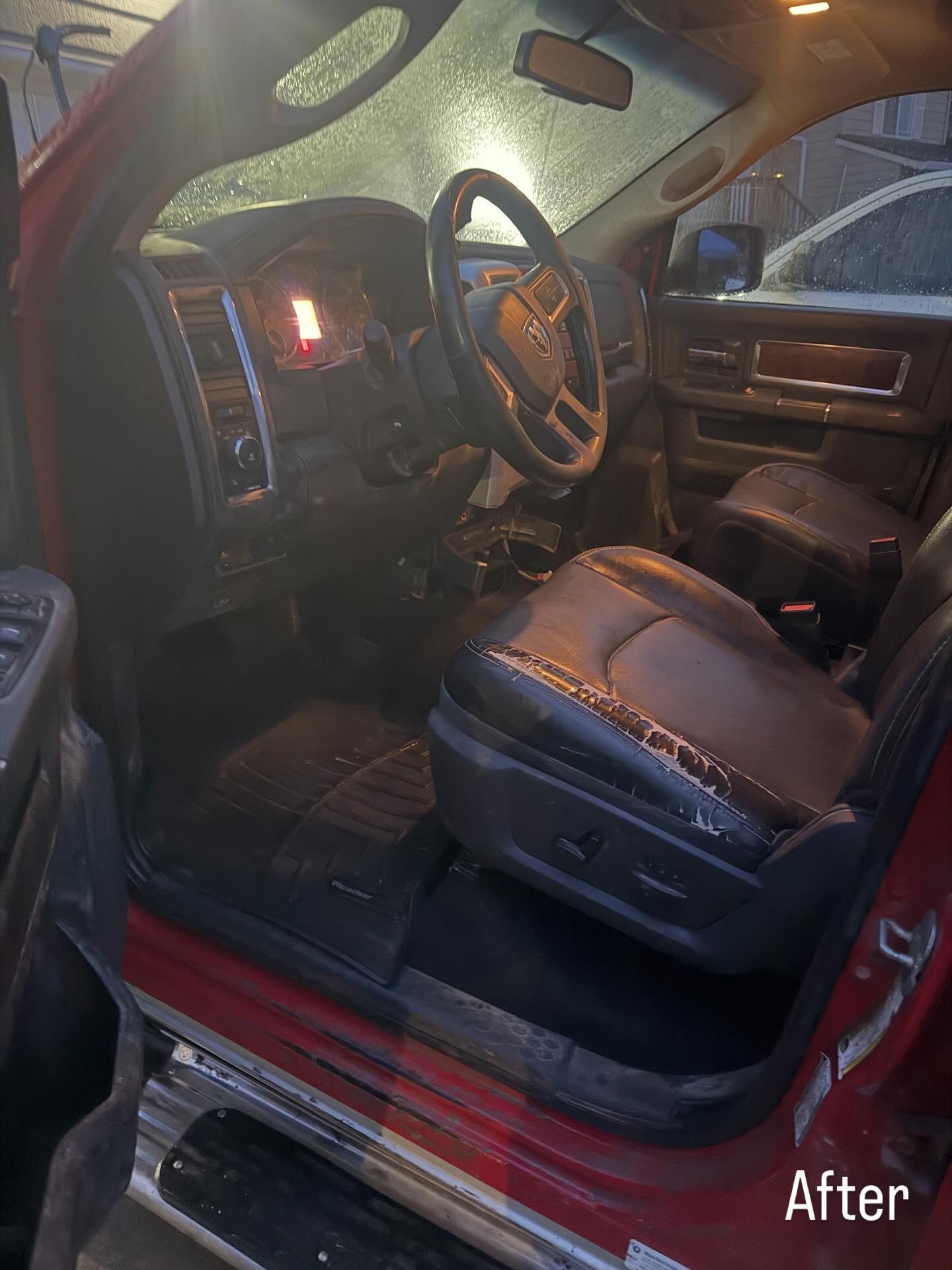 Car interior after cleaning, with black leather seats and red door trim.
