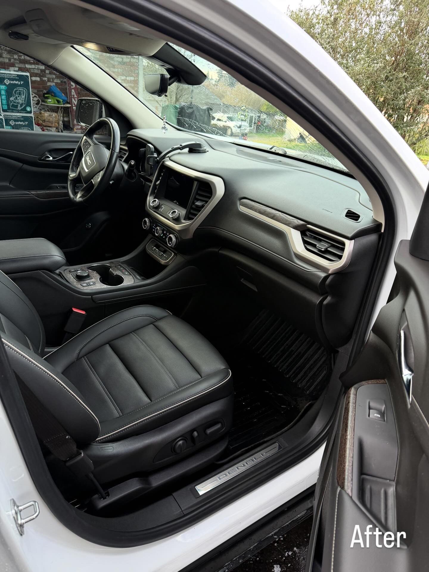 Car interior after cleaning, showing black seats, dashboard, and open passenger door