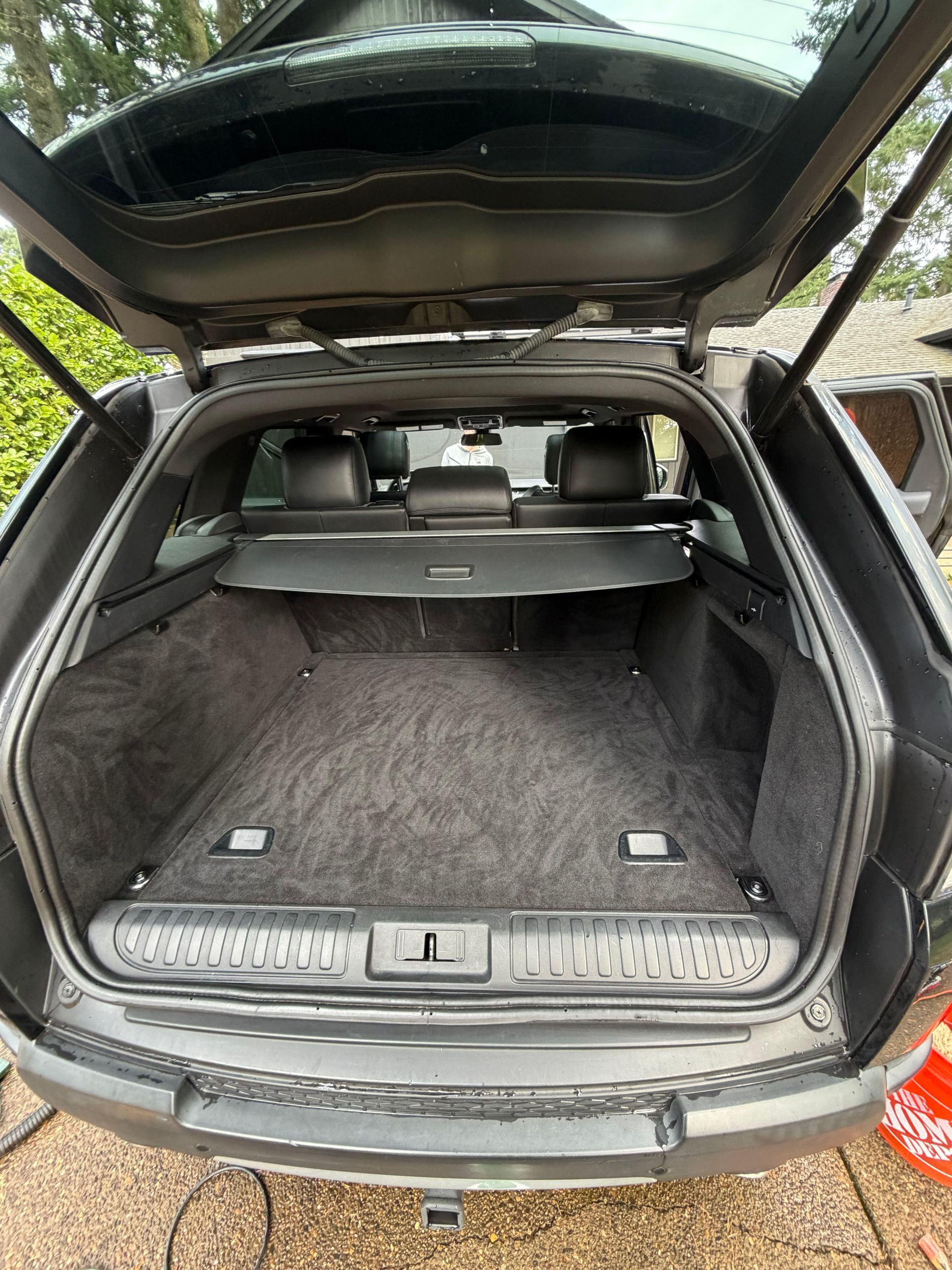 Open SUV trunk with rear seats folded down and a cargo cover in place.