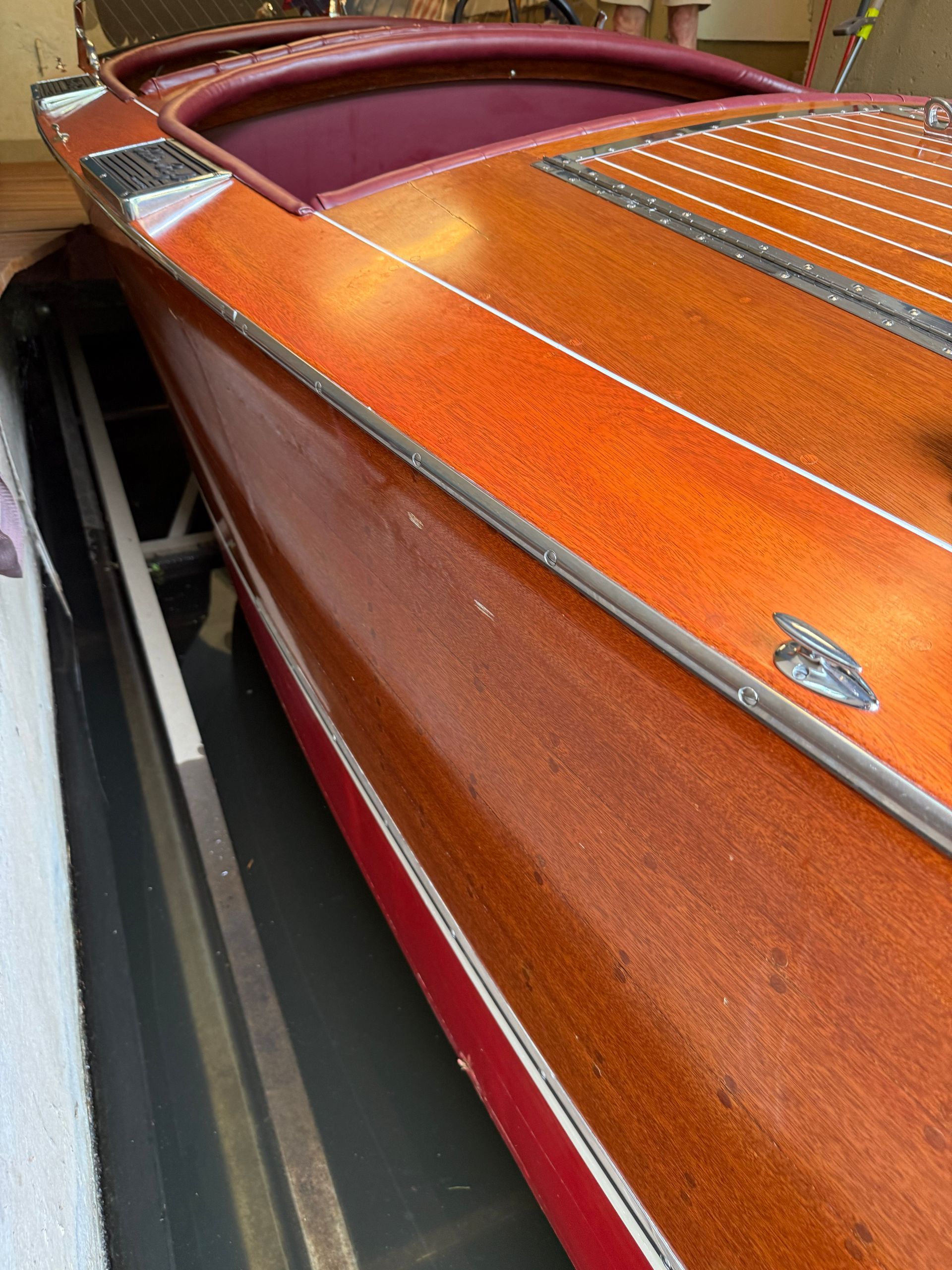 Close-up of an orange vintage speedboat with red trim and maroon cockpit.
