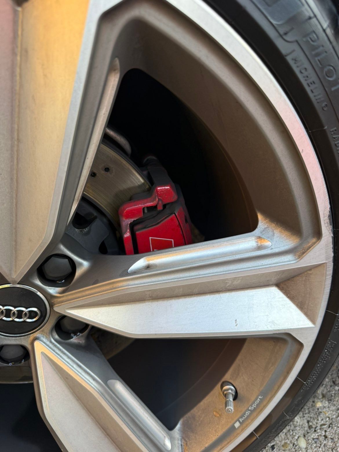 Close-up of an Audi wheel rim with a red brake caliper visible through the spokes