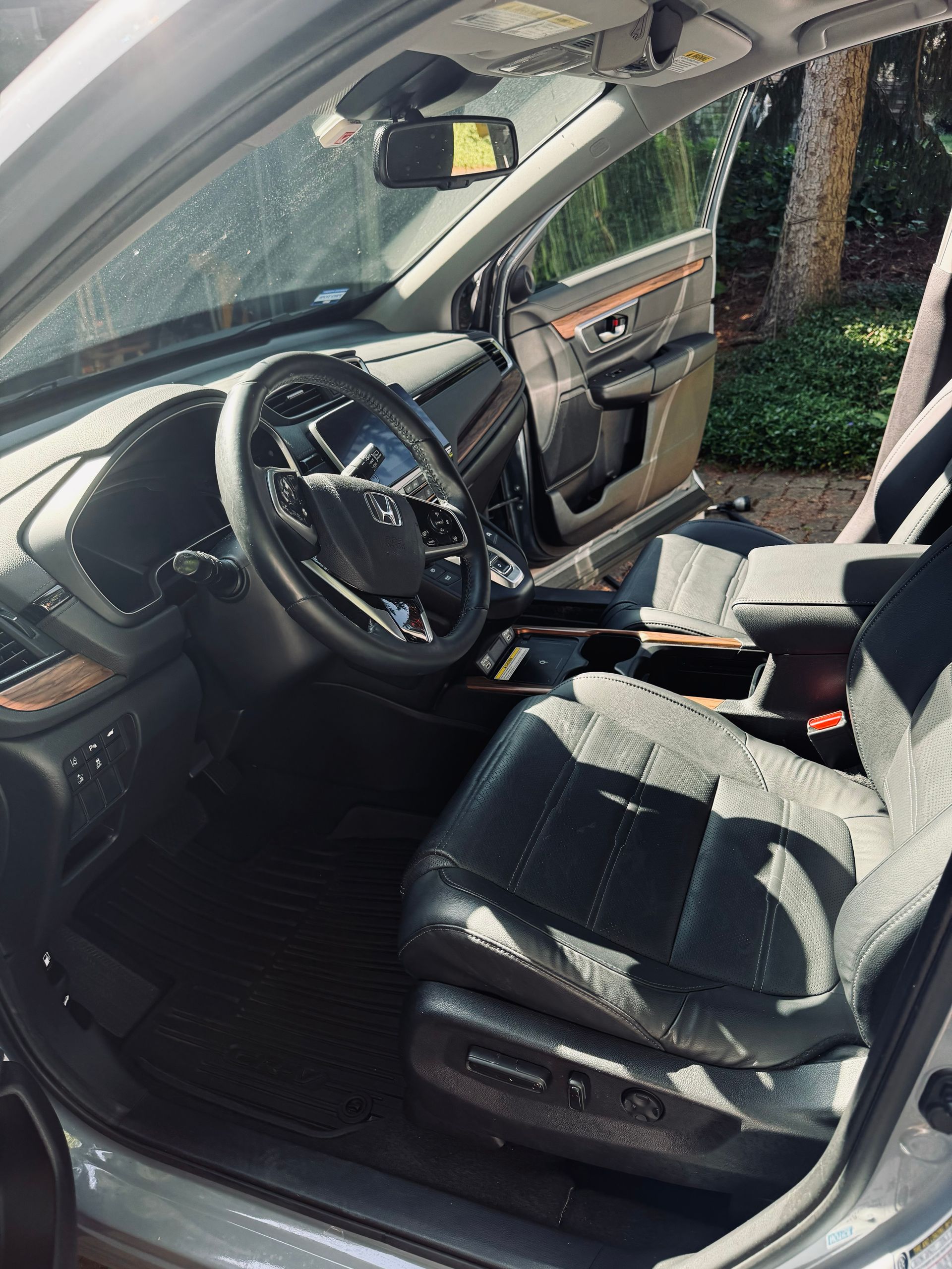 Damaged car interior with deployed driver airbag and broken windshield on the front passenger side.