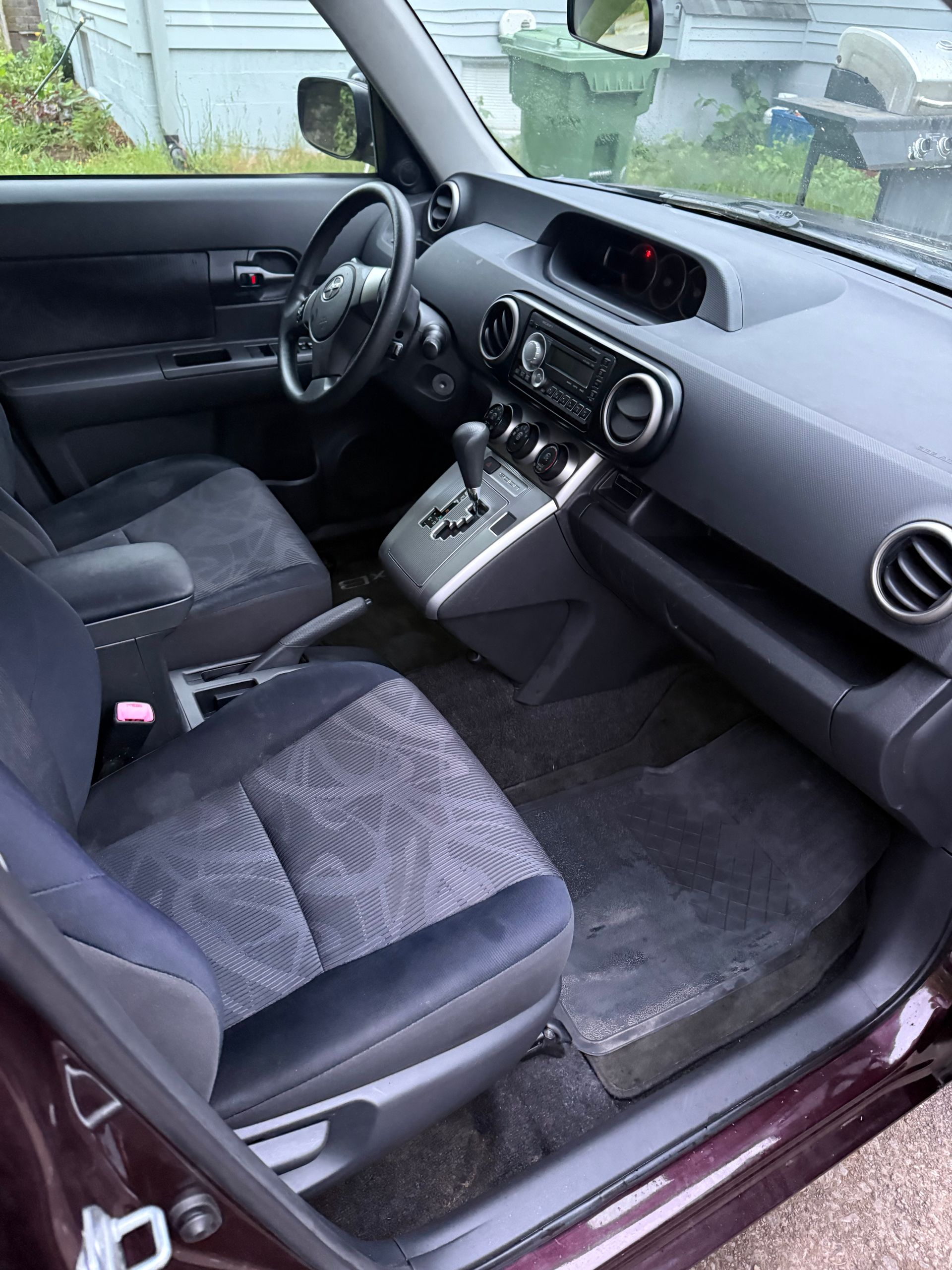 Car interior with black seats and gray dashboard, centered on the front passenger area.