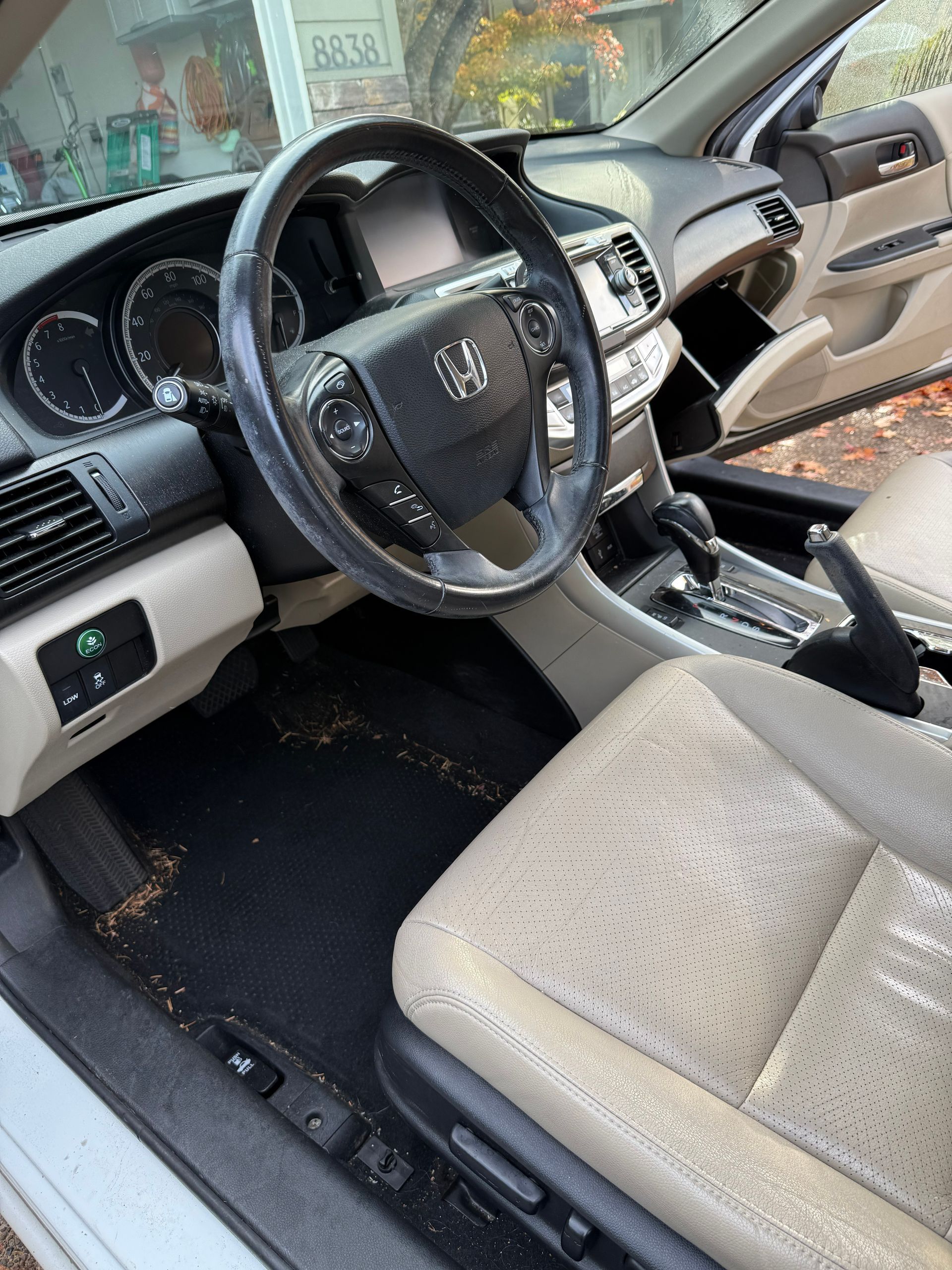 Interior of a Lexus car with beige seats, black dashboard, and the front door open.