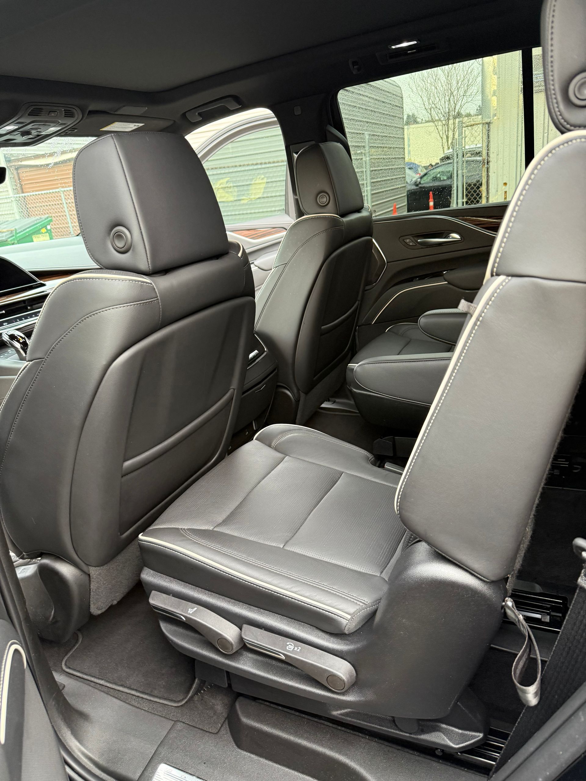 Car interior with black leather seats and a view of the back seat area.