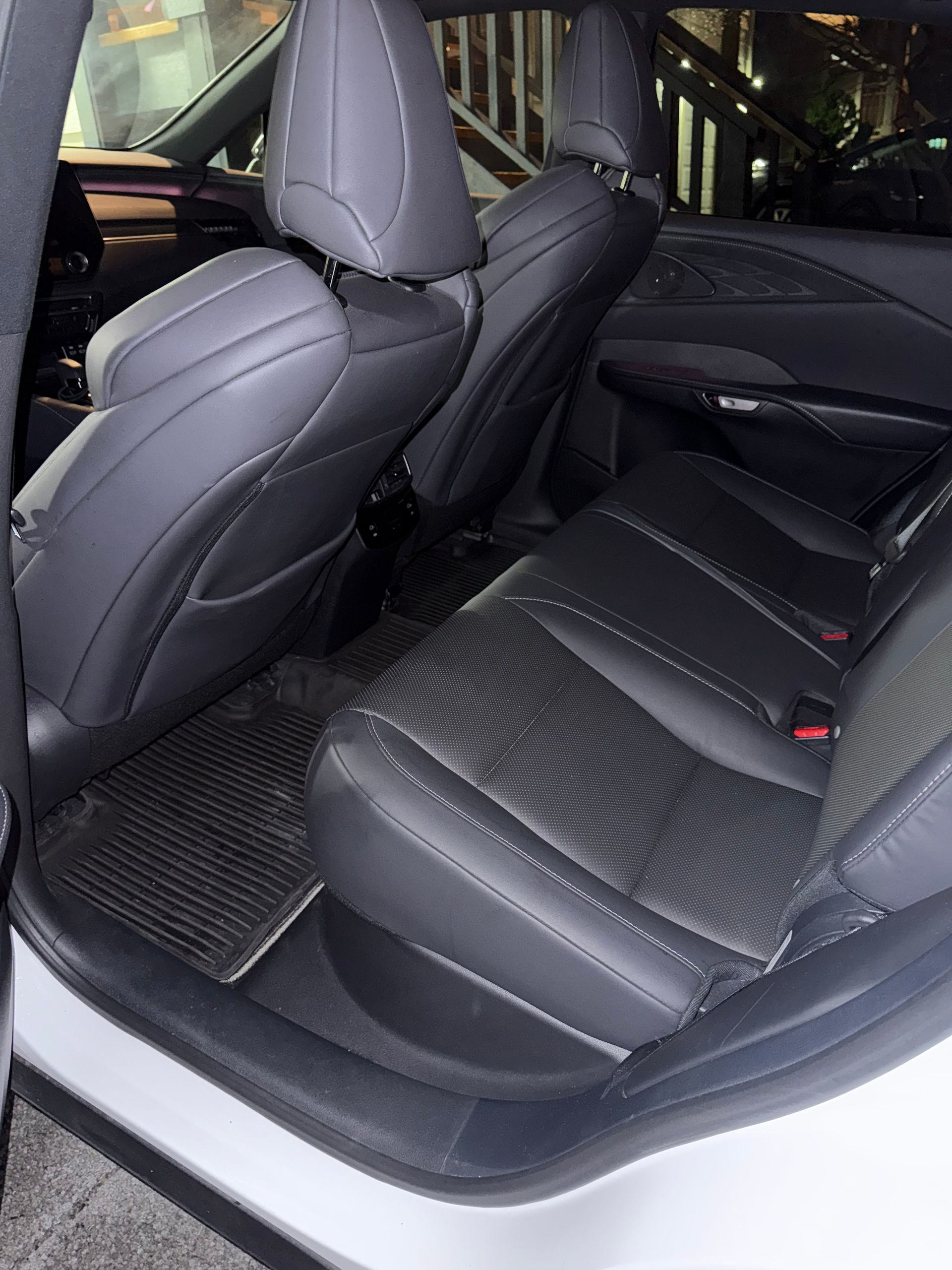 Car interior with black leather rear seats and front seatbacks visible
