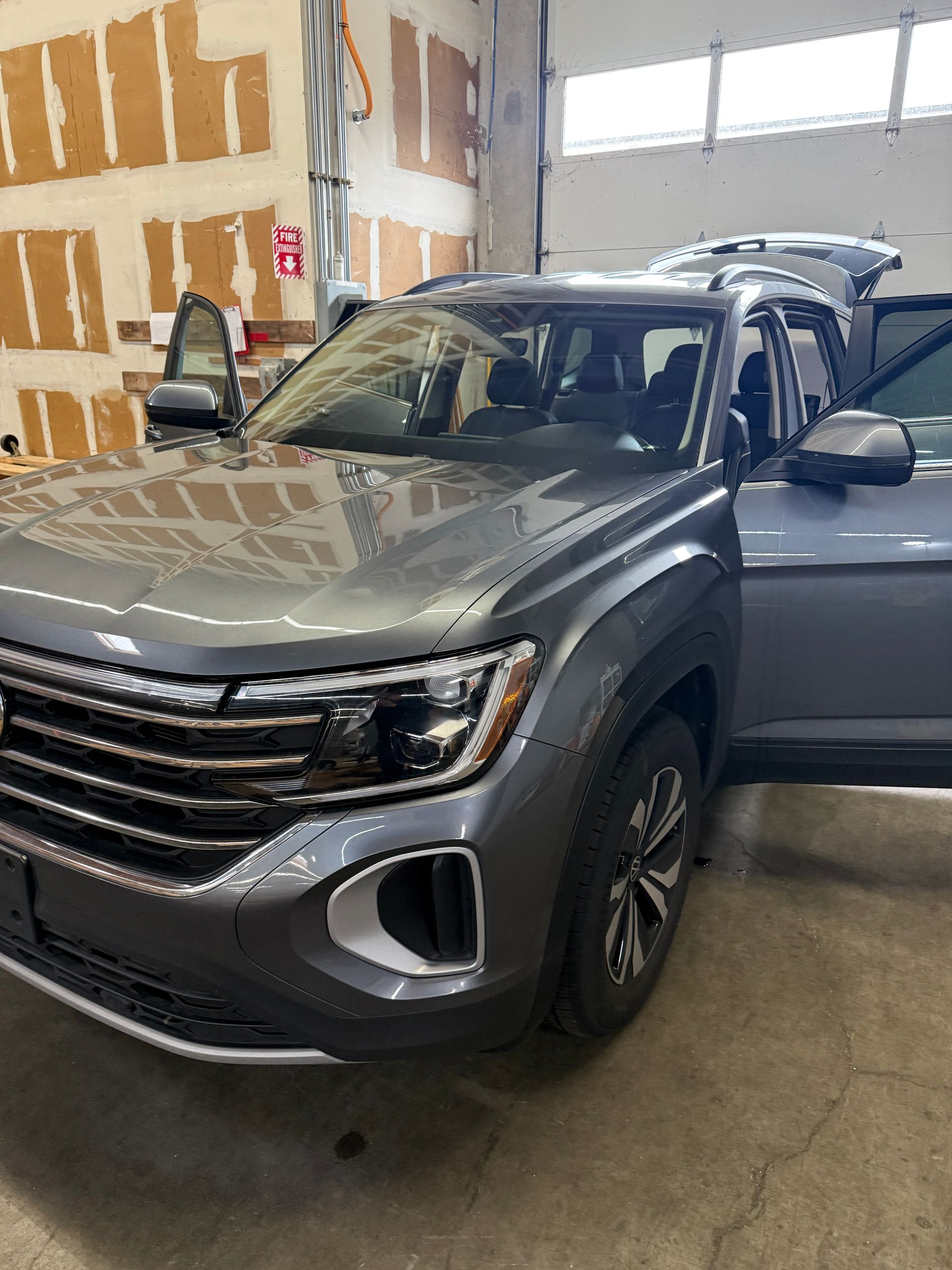 Dark gray SUV parked indoors in a garage or showroom